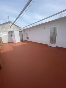 a large room with a red floor and a building at Apartamento CASA EL MORABITO in Puente Genil