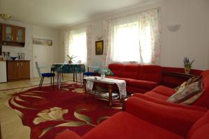a living room with a red couch and a table at Türi Puhkemaja - Murunella in Türi +16 photos