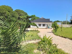 a house with a palm tree in front of it at Nyumba Nzuri in Ukunda, Diani in Ukunda