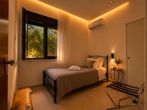 a bedroom with a bed and a window at ELÉNAS slow living villa in Faliraki