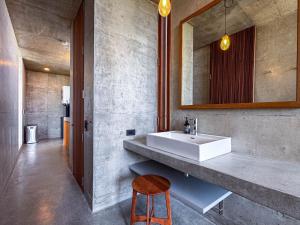 a bathroom with a sink and a stool and a mirror at 大木の宿 Shicari in Yomitan +61 photos