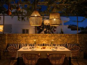 a table with chairs and chandeliers in a restaurant at ELÉNAS slow living villa in Faliraki