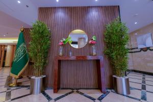a dressing room with two potted trees and a mirror at فندق جادة أجياد Jada Ajyad Hotel in Ajyad