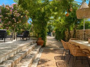 a patio with chairs and a table and trees at ELÉNAS slow living villa in Faliraki