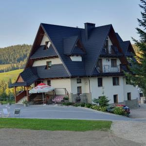 a large house with a gambrel roof at Gościniec Polana Błociska-Na Błociskach in Małe Ciche