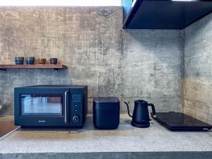 a microwave sitting on a counter next to a blender at 大木の宿 Shicari in Yomitan