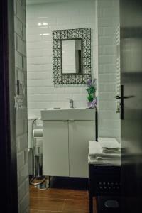 Baño blanco con lavabo y espejo en Apartamentos 1177 en Cuenca