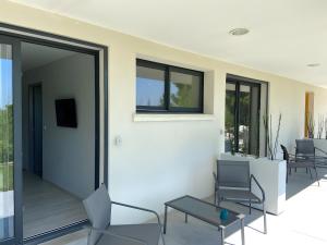 a room with chairs and tables on a patio at Entre Mer Et Pinède Piscine in Bandol