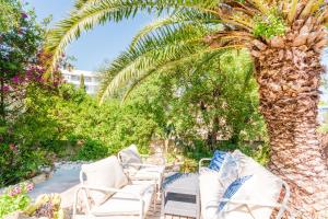 a group of white lounge chairs under a palm tree at Holiday Home Kety in Portals Nous