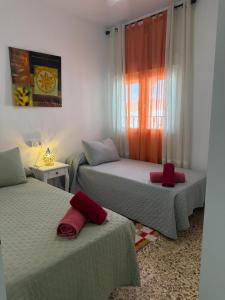 a bedroom with two beds with red pillows on them at Hospederia Ortiz 2 in Níjar