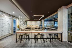 a bar in a restaurant with stools at Amaris Hotel Pekanbaru in Pekanbaru