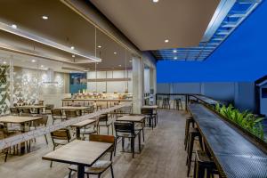 a restaurant with tables and chairs and a bar at Amaris Hotel Pekanbaru in Pekanbaru