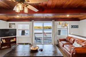 a living room with a couch and a table at Waterfront w/ Prvt Dock & Firepit | Sleeps 8 in Acton