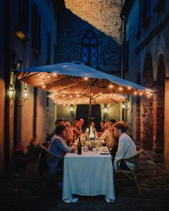 a group of people sitting at a table under an umbrella at Erta Terra Hotel in Mazzolla
