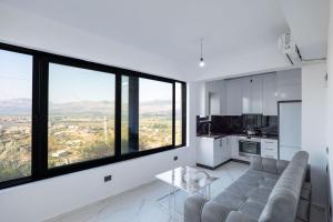 a living room with a couch and large windows at Lina's House in Sarandë
