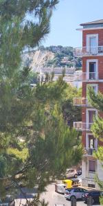 a building with cars parked in a parking lot at Miramare Apartment in Ancona