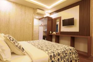 a bedroom with a bed and a tv on a wall at Maresia in Gili Islands