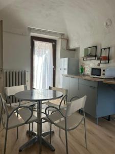 a kitchen with a table and chairs in a kitchen at Pola's House Biella Bio in Biella