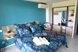 a blue bedroom with a bed with pillows at Entre Mer Et Pinède Piscine in Bandol