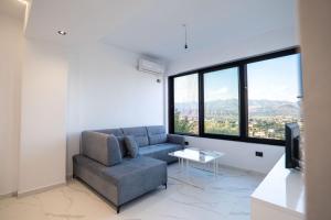 a living room with a couch and a large window at Lina's House in Sarandë