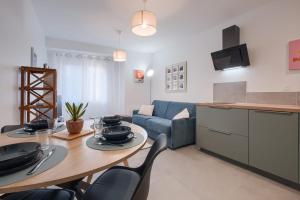 a kitchen and living room with a table and a couch at Le Cocon de Cossé - Wifi - 300m Centre in Cossé-le-Vivien