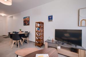 a living room with a large flat screen tv and a table at Le Cocon de Cossé - Wifi - 300m Centre in Cossé-le-Vivien +7 photos