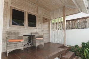 a porch with a table and chairs and windows at Maresia in Gili Islands
