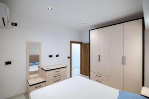 a bedroom with white cabinets and a mirror at Lina's House in Sarandë