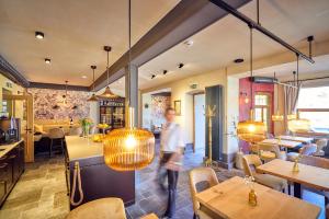 a person walking through a restaurant with lights at Hotel Lahneck in Nievern
