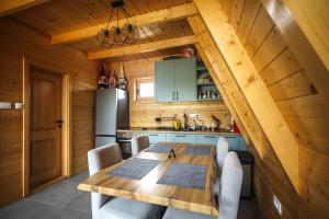 a kitchen with a wooden table and a refrigerator at Wolf Ridge Mountain Cabin Montenegro in Plužine
