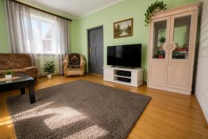 a living room with a flat screen tv on a white cabinet at Nad stawem dom in Pietkowo