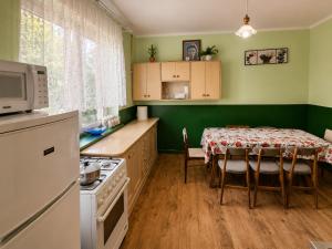 a kitchen with a table and a kitchen with green walls at Nad stawem dom in Pietkowo
