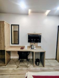 a desk in a room with a chair and a mirror at Hotel Annex International Near International Airport in Mumbai