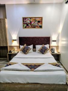 a hotel room with two beds and two tables at Hotel Annex International Near International Airport in Mumbai