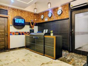 an office with clocks on the wall and a desk at Hotel Annex International Near International Airport in Mumbai