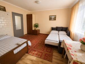 a bedroom with two beds and a red rug at Nad stawem dom in Pietkowo
