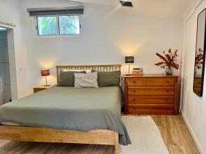 a bedroom with a bed and a dresser and a window at Casa Bolacha in Colares