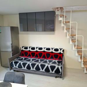 a room with a bed and a spiral staircase at Melnaragė in Melnragė