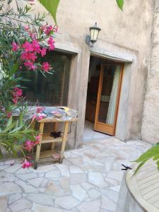 a table in front of a building with pink flowers at La Casa in Montagnac