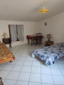 a room with two beds and a table in it at La Casa in Montagnac