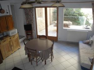 a kitchen with a table and chairs and a balcony at La Casa in Montagnac