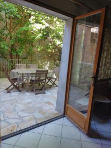 a sliding glass door to a patio with a table and chairs at La Casa in Montagnac +4 photos