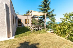 a patio with a table and chairs on the side of a house at Natural Villas Trabzon in Komera