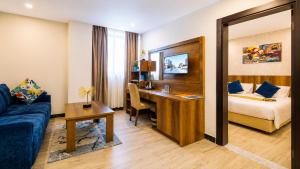 a hotel room with a desk and a bed at Jalo Hotel - Shashemene in Shashemenē