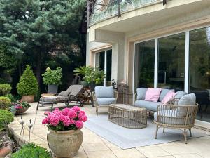 a patio with chairs and a couch and flowers at Viktoria House in Balatonszárszó