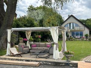 a gazebo with a couch and chairs under it at Viktoria House in Balatonszárszó