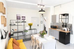a kitchen and living room with a table and chairs at Pasta Kvartāls Inn in Ogre