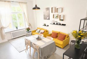 a living room with a table and a yellow couch at Pasta Kvartāls Inn in Ogre