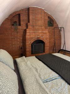 a brick fireplace with two beds in front of it at East Mountain Villa - Private Nature Retreat in Baranja in Batina
