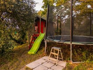 a playground with a trampoline and a green slide at Capozucca Home in Città della Pieve